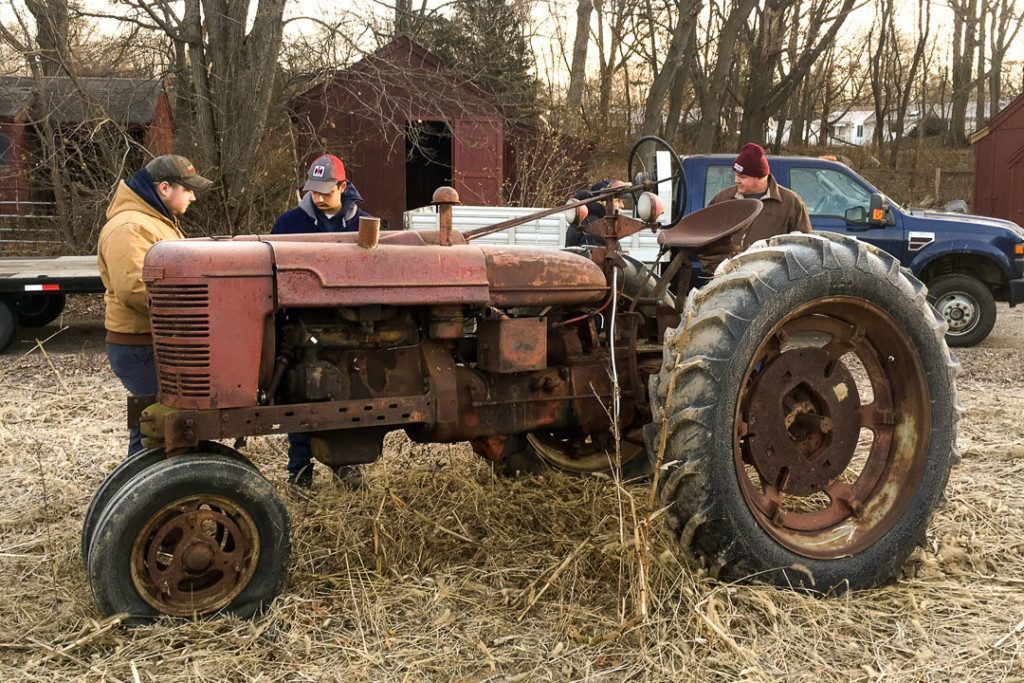 The Wamogo Regional High School Tractor Restoration Program pulling an old rusted tractor from a field.