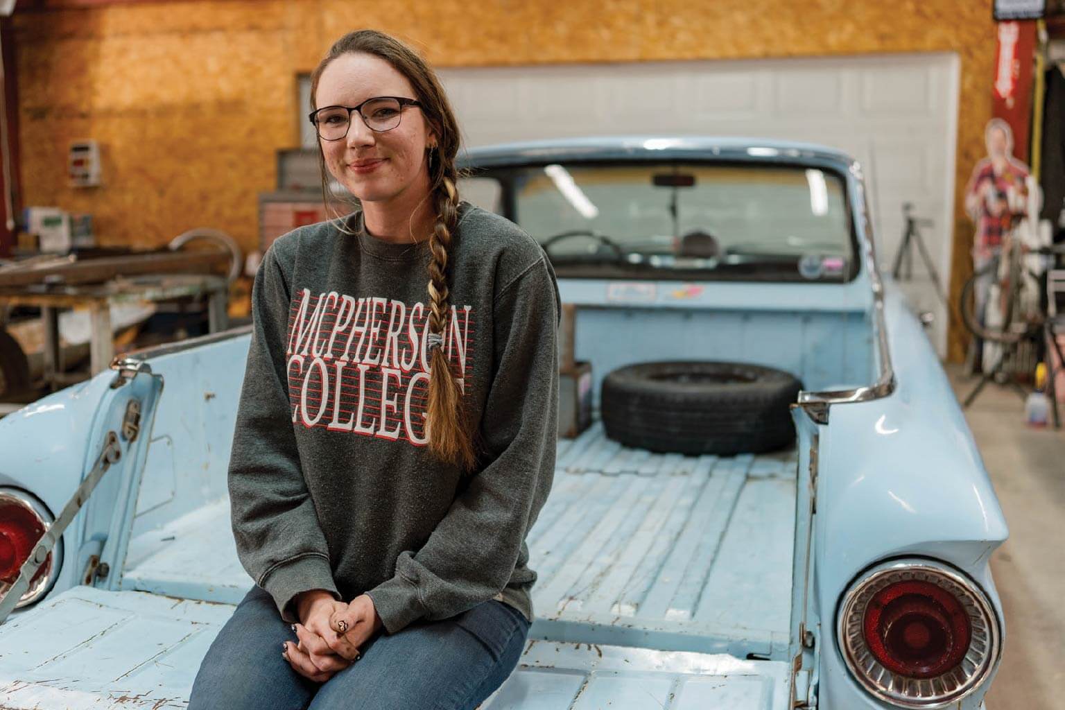 A girl sitting in a truck bed with folded hands
